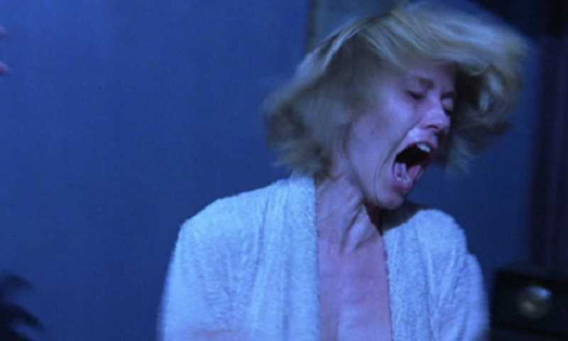 Shelley Duvall como Wendy Torrance em O Iluminado, gritando de terror com cabelos esvoaçantes sob luz azulada