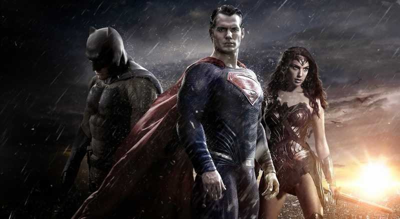 Batman, Superman e Mulher-Maravilha lado a lado sob a chuva, em arte de divulgação