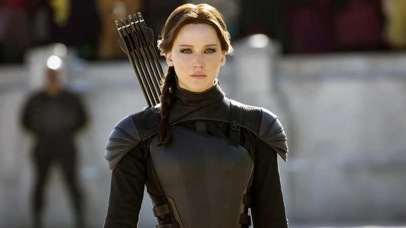 Katniss Everdeen com a armadura do Tordo e uma aljava de flechas nas costas, em cena da saga Jogos Vorazes